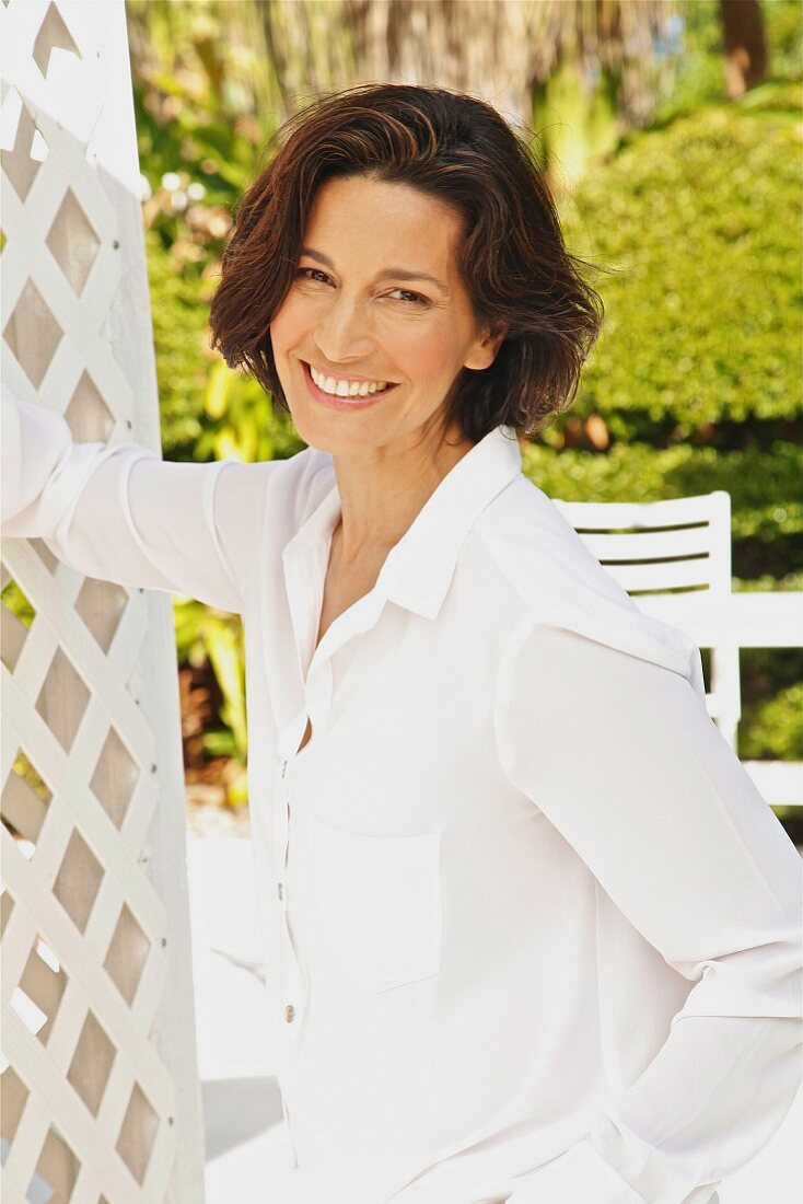 A brunette woman wearing a white blouse