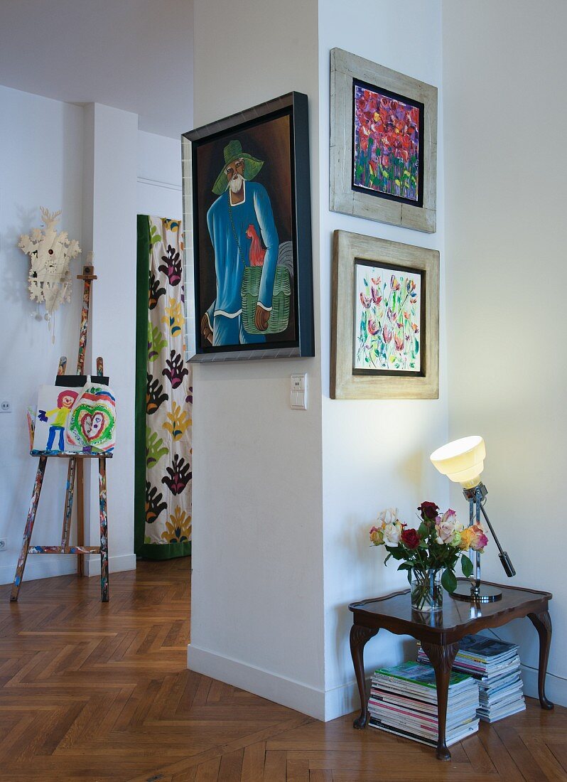 Framed pictures on hallway wall in period apartment with herringbone parquet floor