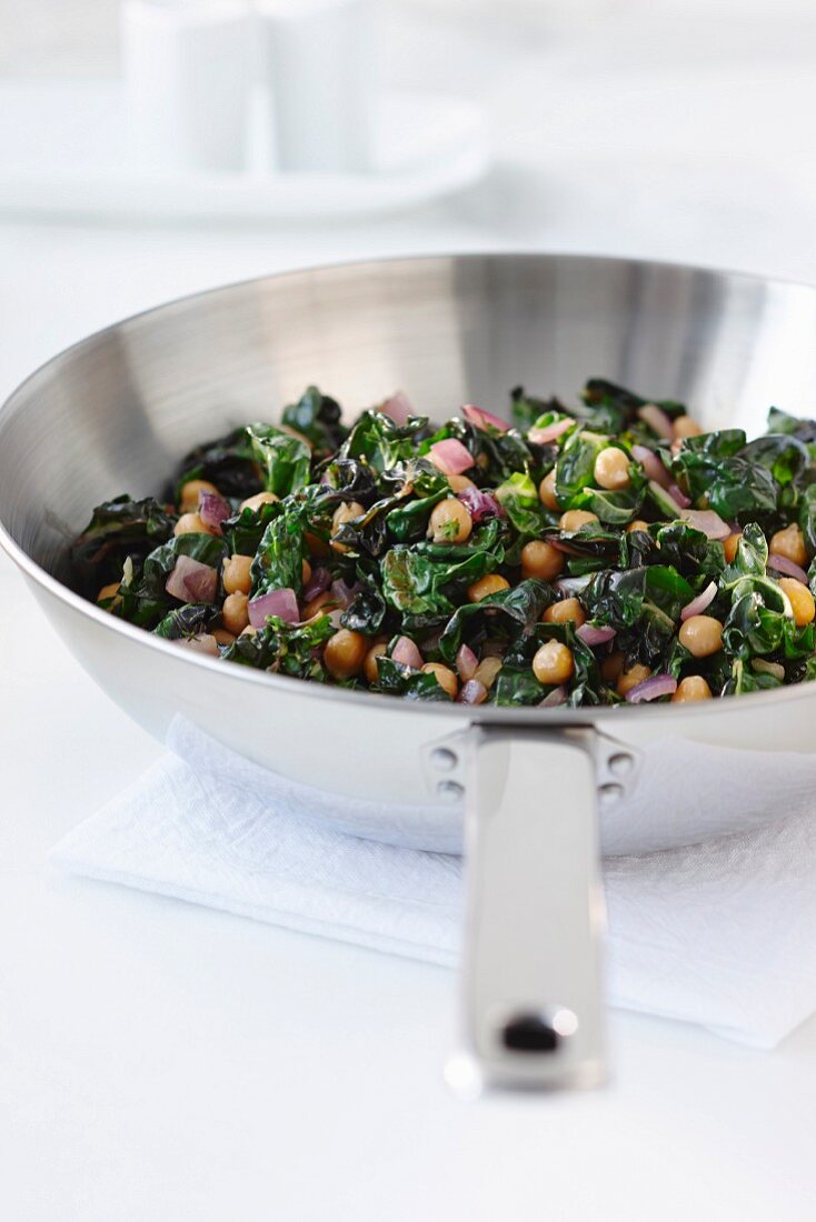 Spinach with chickpeas and red onions in a pan