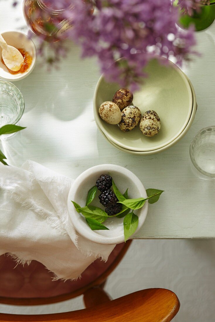 A dining table with fig jam, blackberries and duck eggs