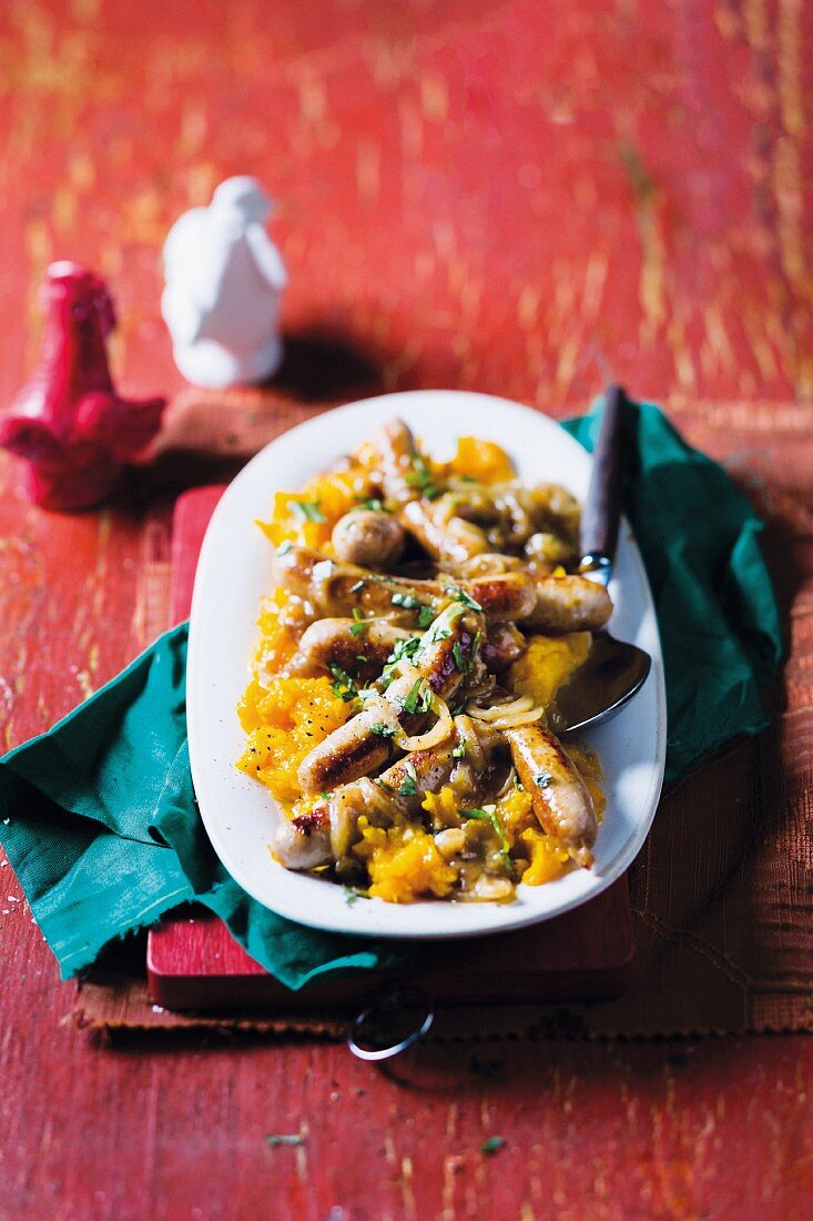 Sausages with onions on a bed of butternut squash purée