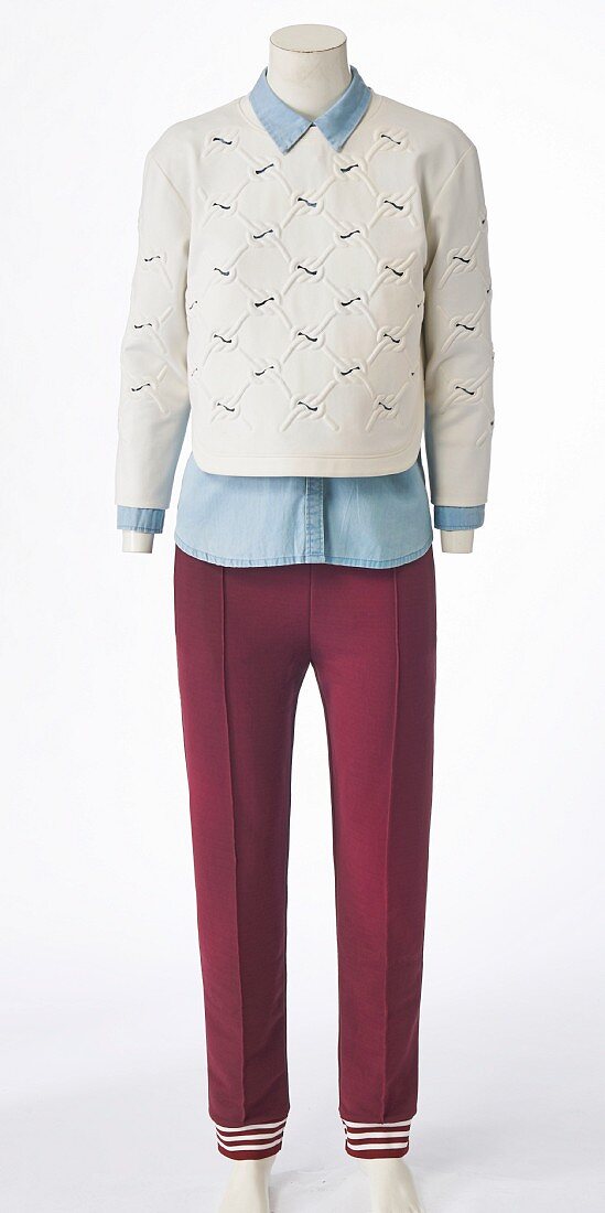 A denim shirt, white cotton jumper and burgundy trousers on a headless mannequin
