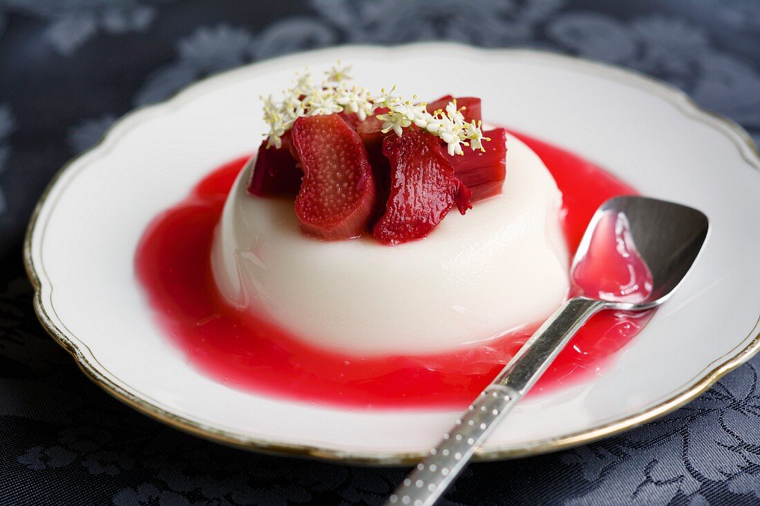 Panna cotta with rhubarb coulis garnished with elderflowers