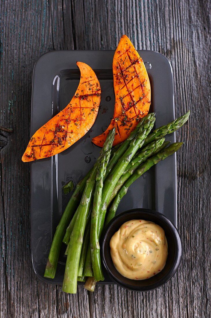 Cooked green asparagus and grilled sweet potato with a dip
