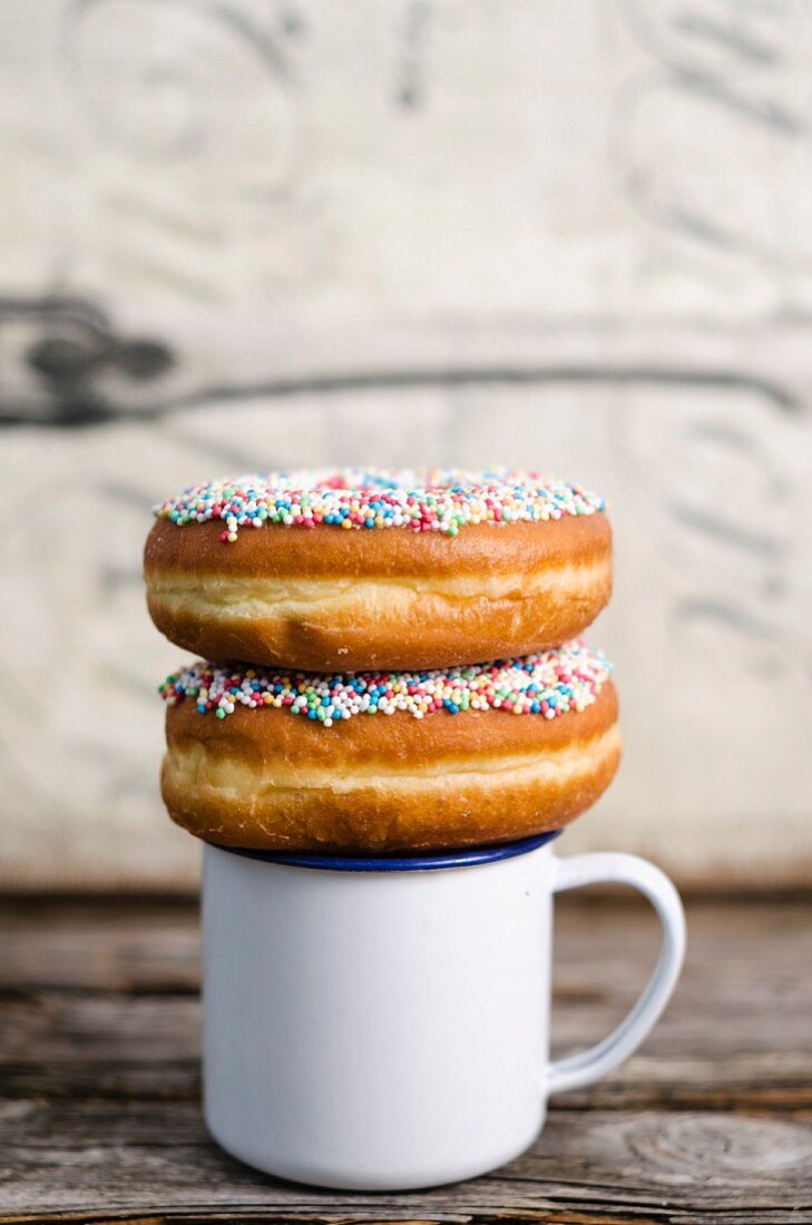 Doughnuts with sugar sprinkles on top of a coffee cup