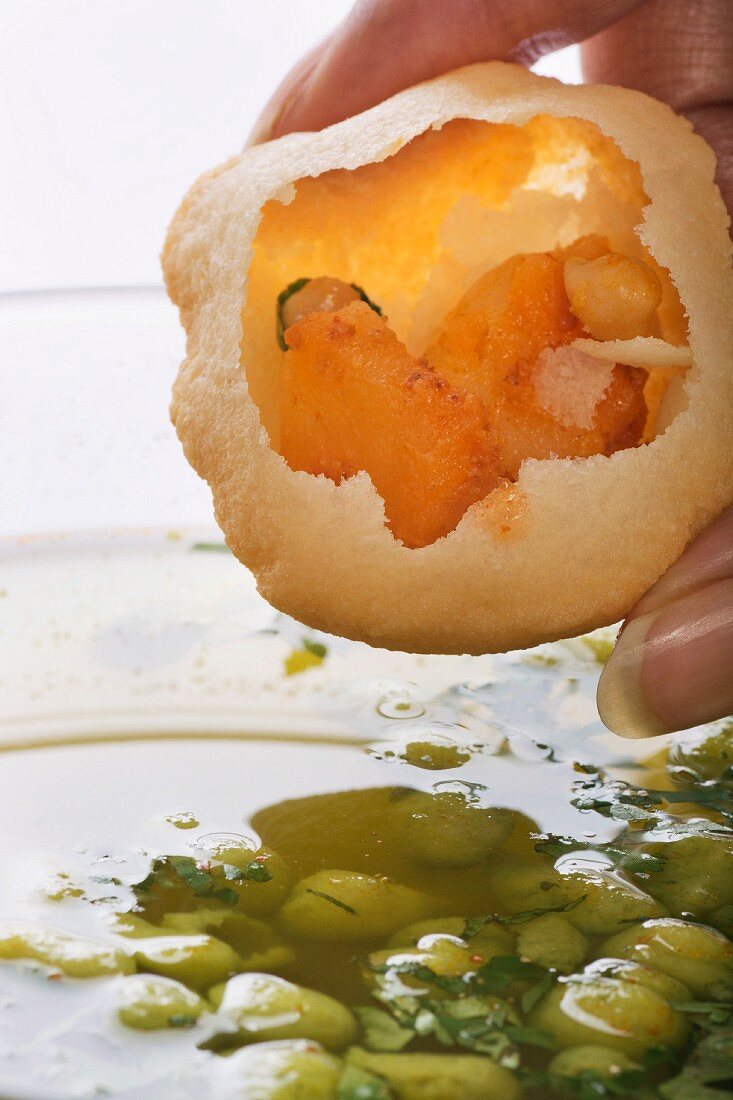 An Indian woman holding panipuri (stuffed bread ball, India)