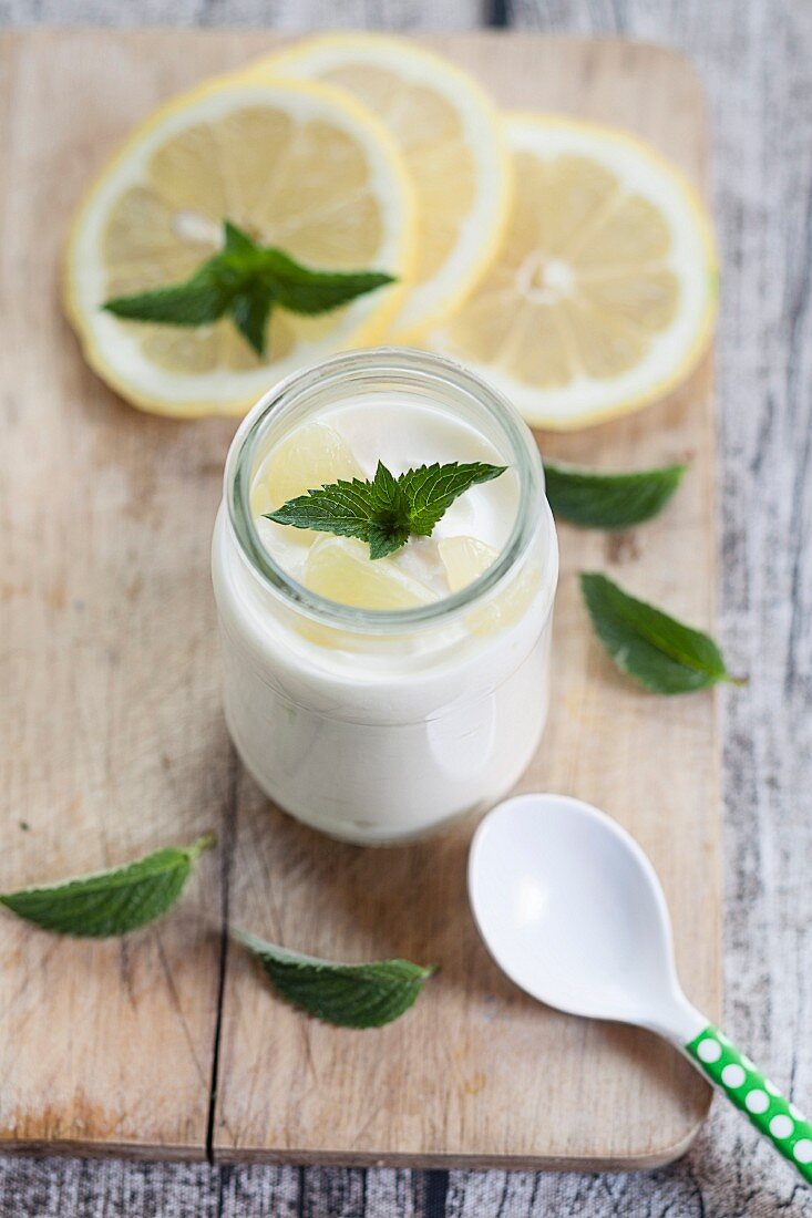 Zitronenjoghurt mit Zitronenscheiben und Minze