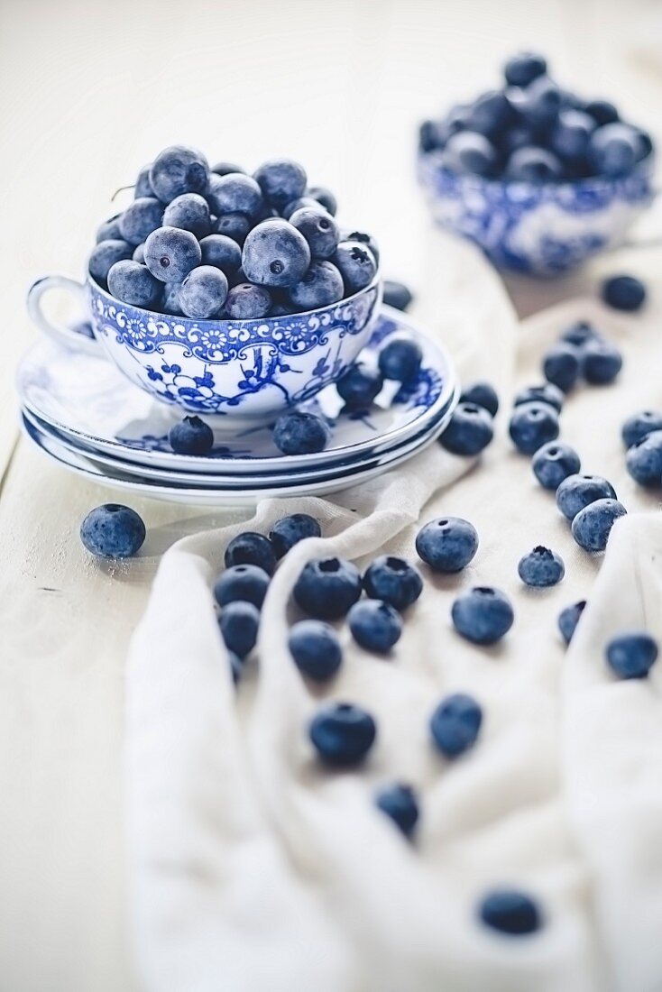 Blueberries in and around a teacup