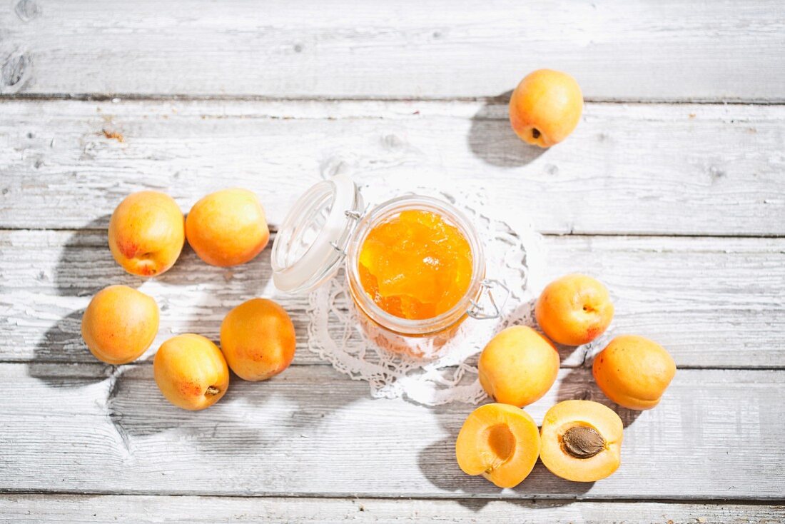 A jar of apricot jam and fresh apricots