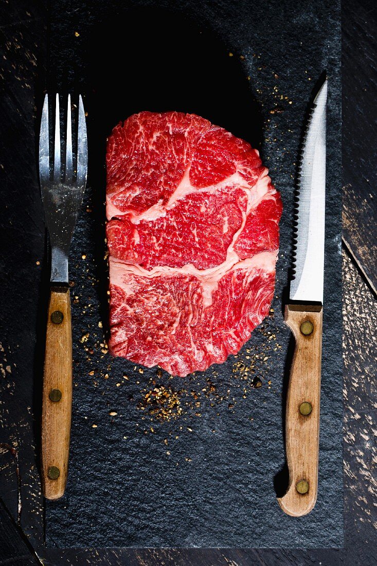 Rohes Rindersteak mit Pfeffer, Messer und Gabel