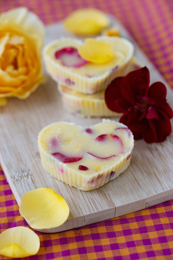 Heart-shaped rose butter and rose petals on a chopping board