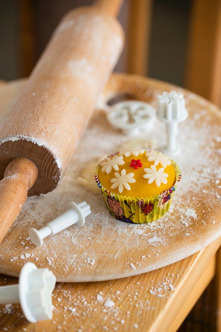 Cupcakes with marzipan fondant surrounded by baking utensils