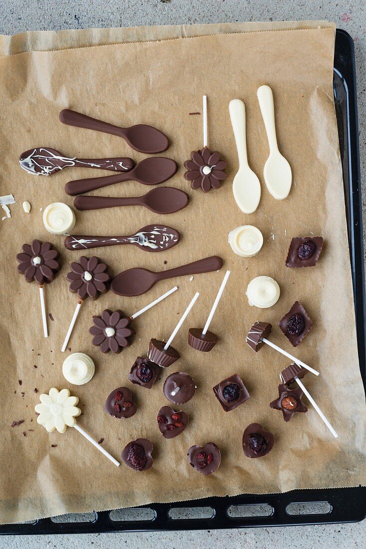 Hausgemachte Pralinen und Schokoladenlöffel auf Backpapier