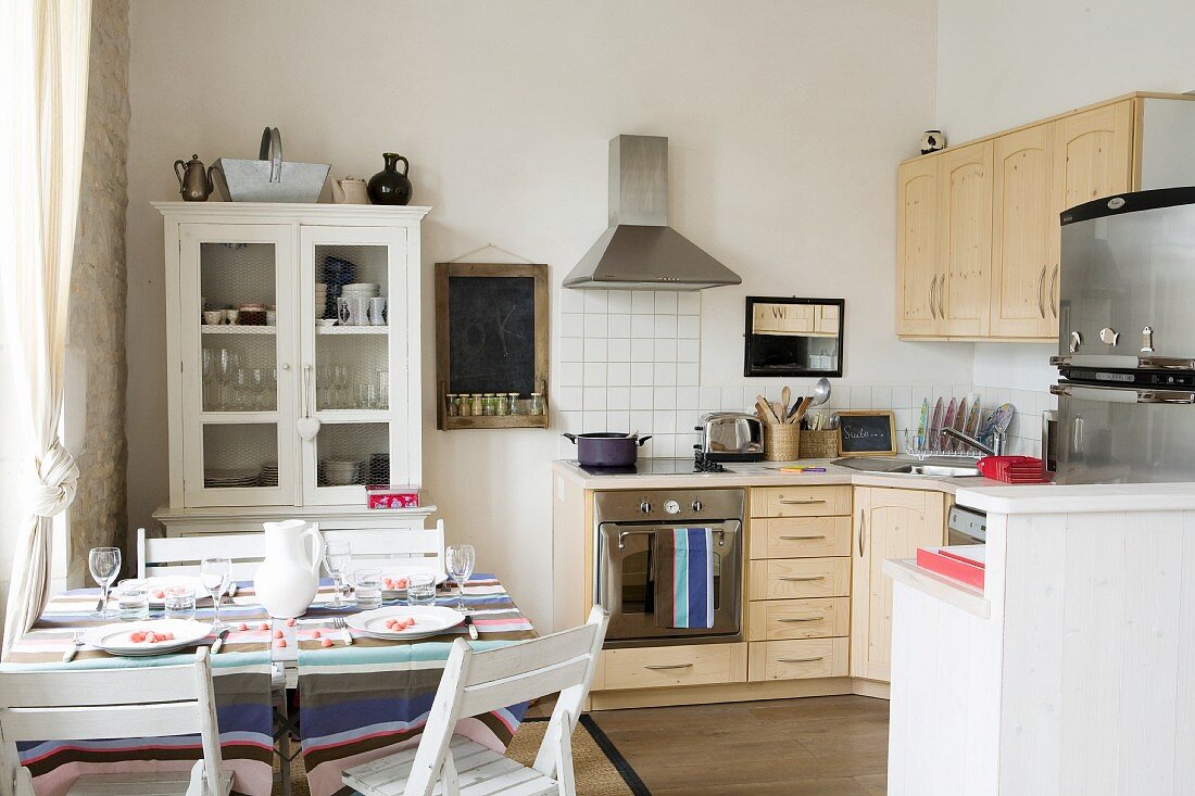 Set table in kitchen-dining room with wooden cabinets