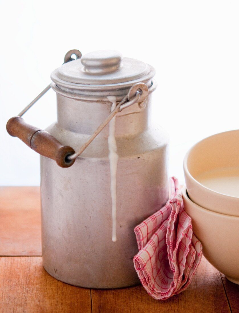 A churn of milk, a tea towel and ceramic bowls