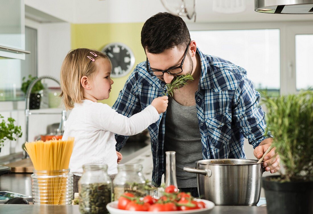 A father and daughter cooking in a kitchen