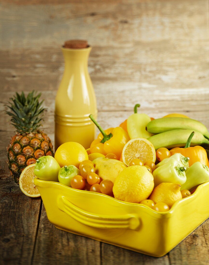 Various yellow fruits and vegetables in a ceramic dish