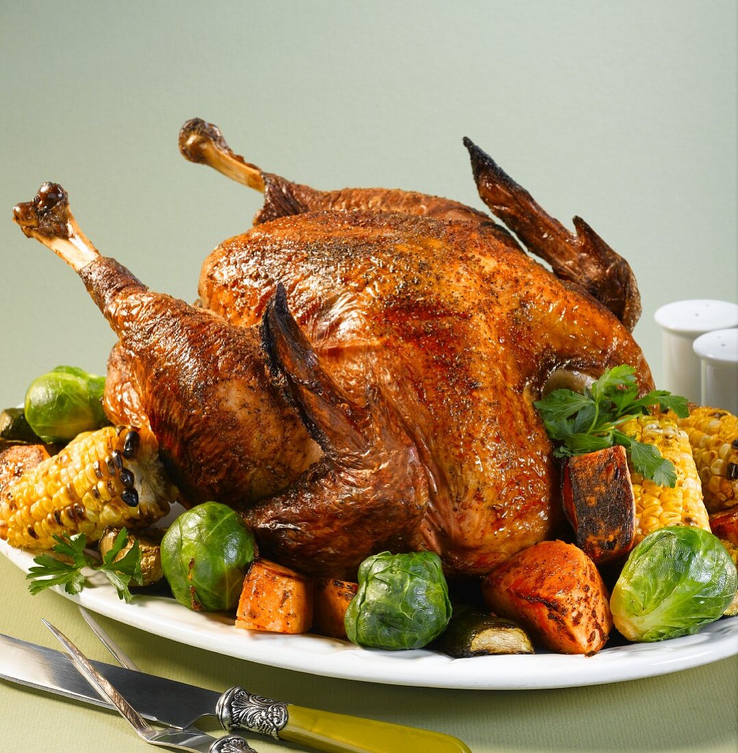Roast turkey with Brussels sprouts, corn cobs and sweet potatoes