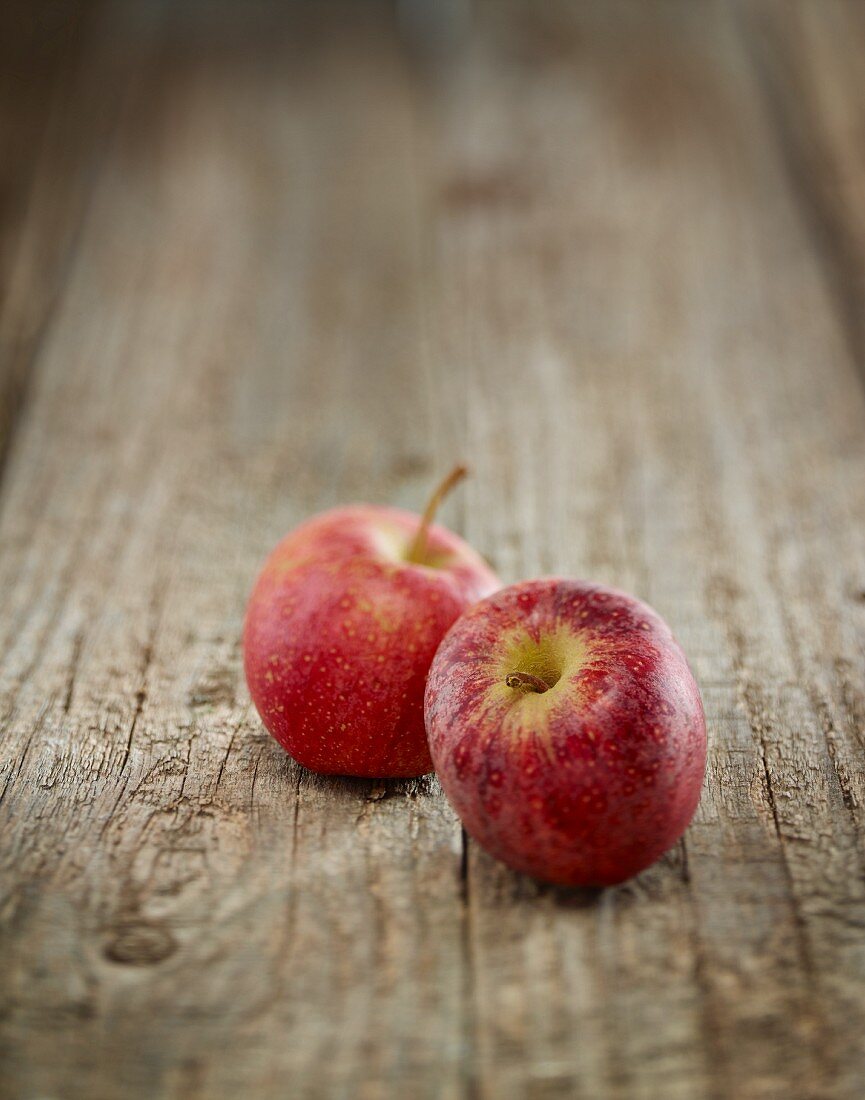 Zwei rote Äpfel auf Holzuntergrund