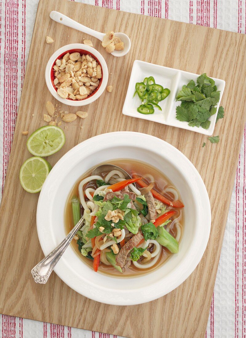 Suppe mit Rindfleisch, Ingwer, Nudeln, Erdnüssen und Koriandergrün (Asien)
