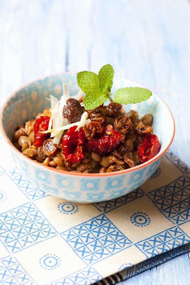 Lentil salad with onions, dried tomatoes, raisins, olives and mint