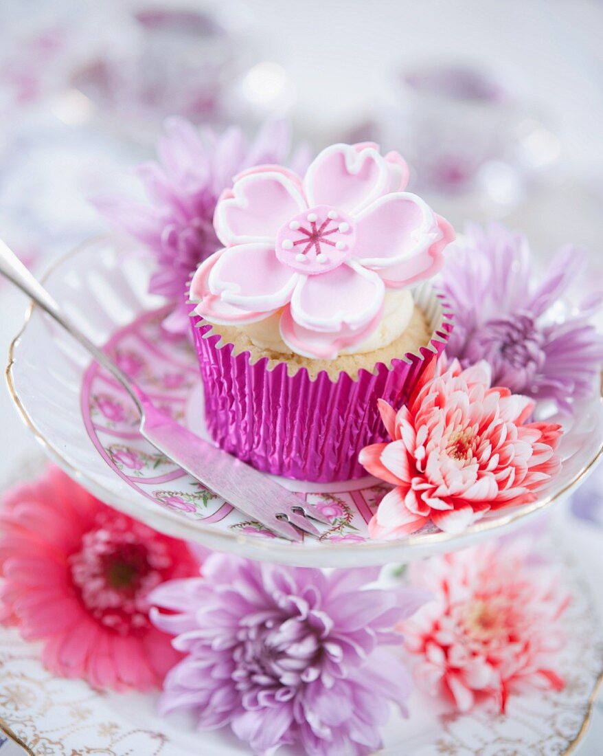 A cupcake decorated with a fondant flower