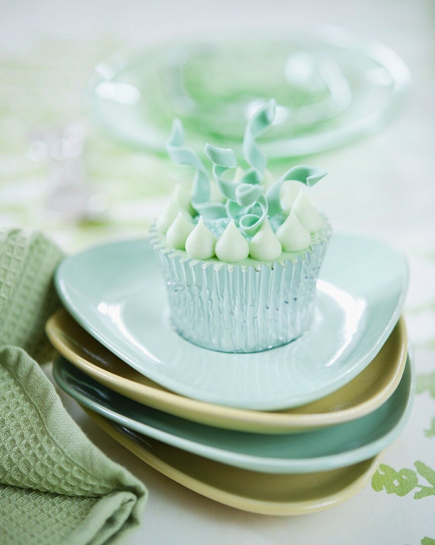An elegant cupcake decorated with curly fondant ribbons