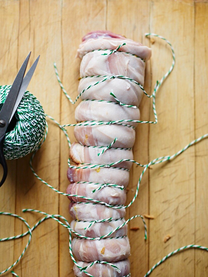 Suckling pig roulade being tied