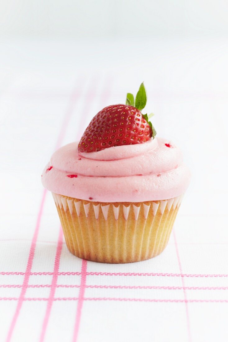 A cupcake topped with a strawberry