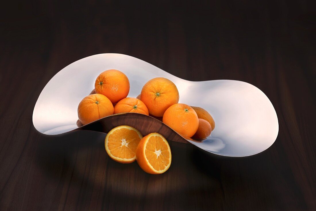 Oranges in a curved stainless steel dish