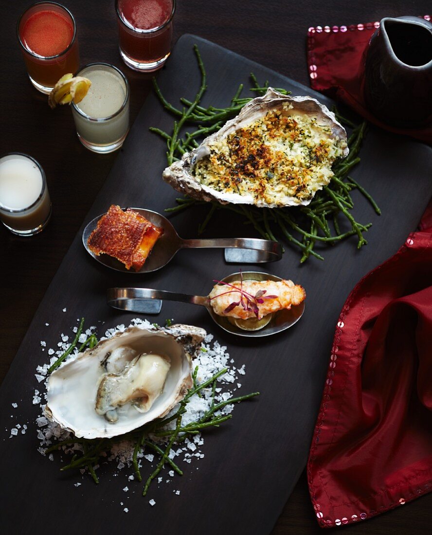 Fischplatte mit Austern auf Queller, Fisch mit Sauce Mornay, frittierten Garnelen und knusprigem enthäuteten Fisch