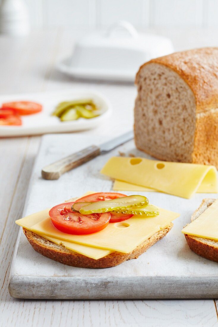 A slice of wholemeal bread topped with tomatoes, gherkins and Emmentaler cheese