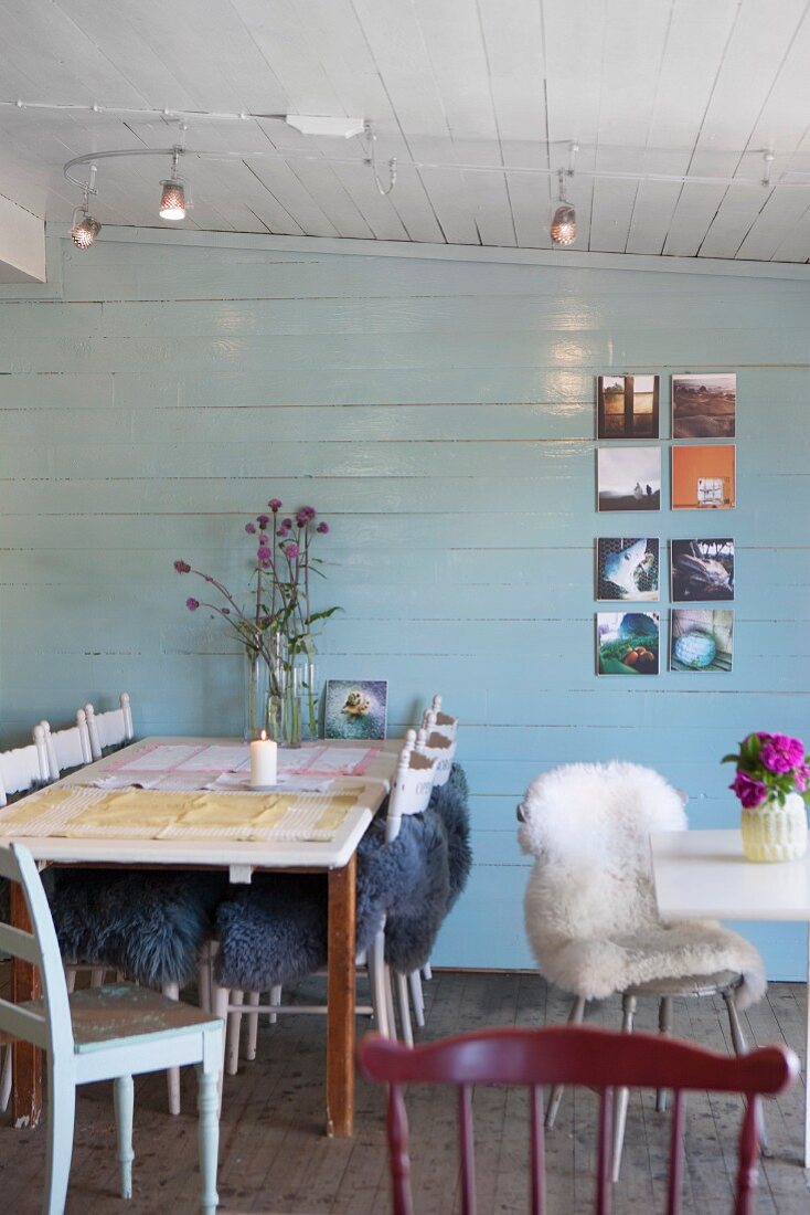 Tische und Stühle teilweise mit Tierfell im Restaurant, mit heller Holzverkleidung an Wand und auf Decke