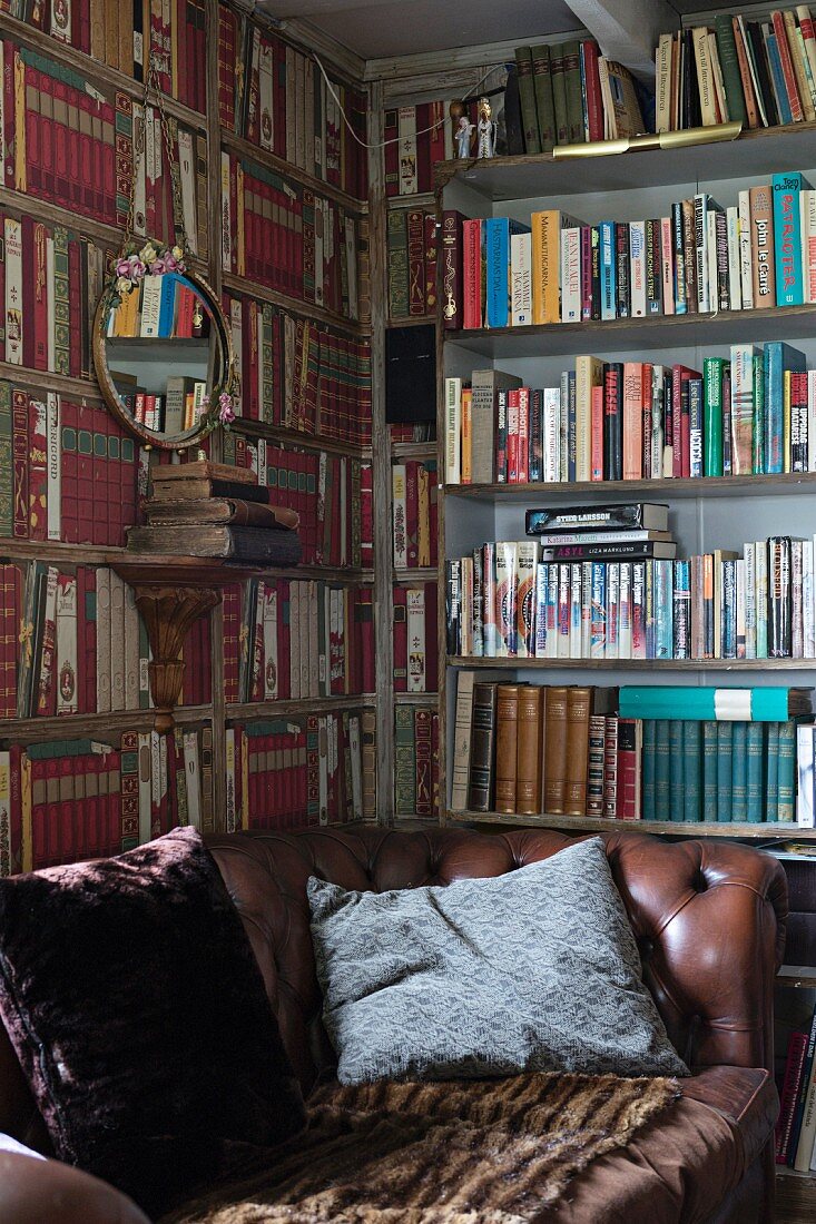 Brown leather couch with scatter cushions in front of bookcases