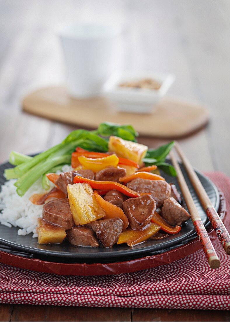 Schweinefleisch mit Ananas, Möhren, Paprika und Reis (Asien)