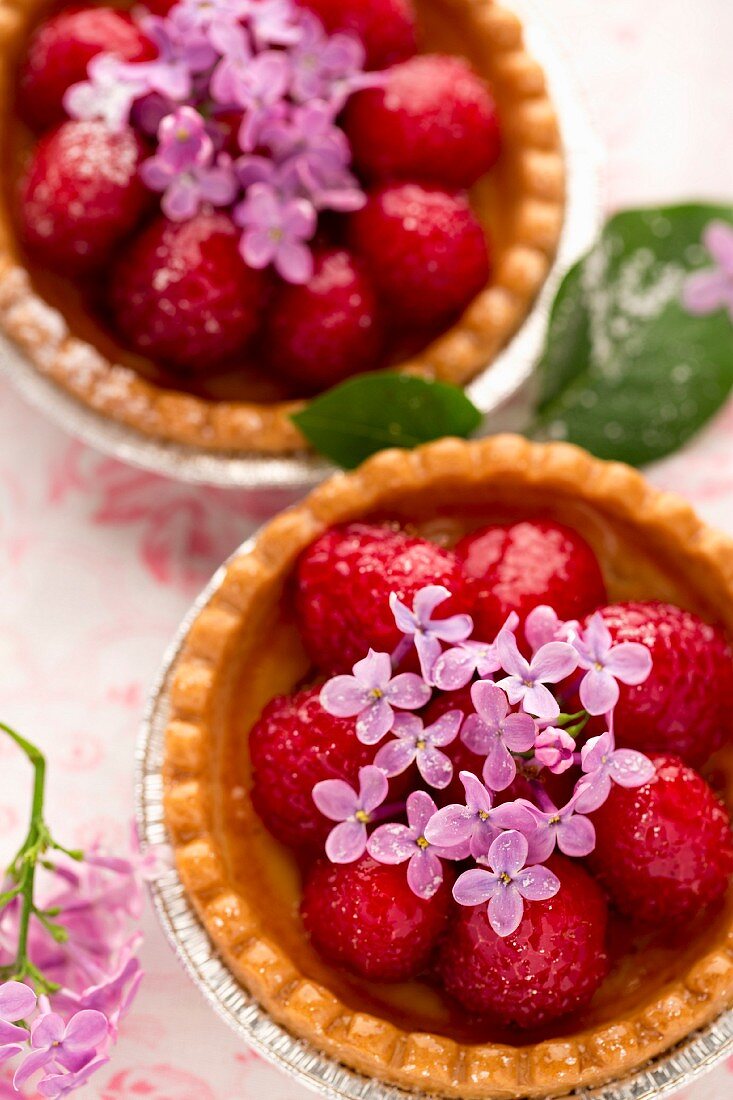 Strawberry tartlets decorated with lilac blossoms