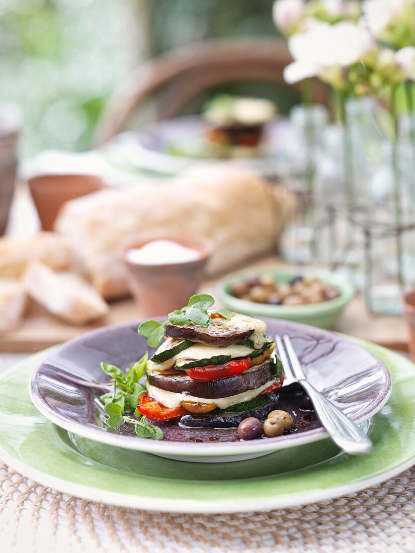 An aubergine tower with olives and mozzarella