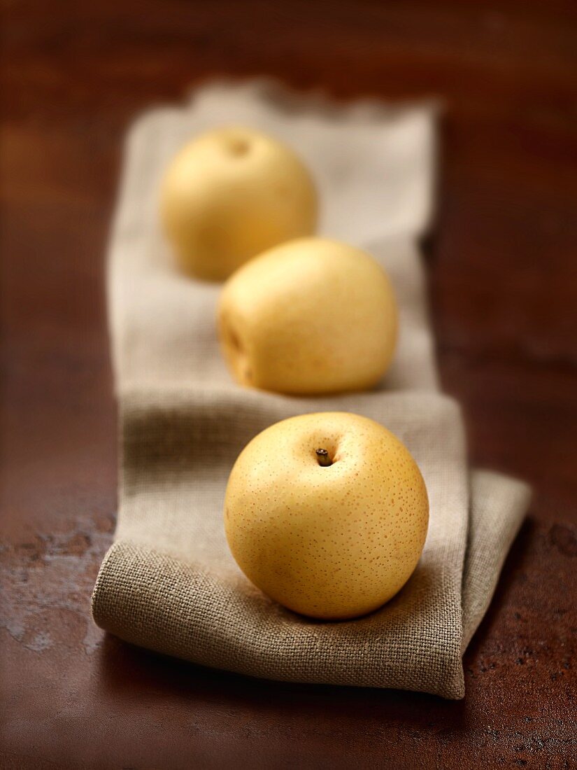 Three nashi pears on a linen cloth