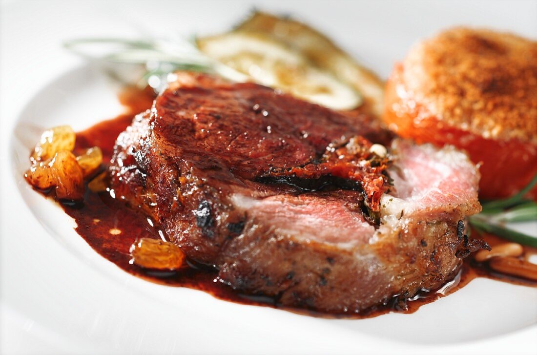 Roast lamb with raisin sauce and stuffed tomatoes