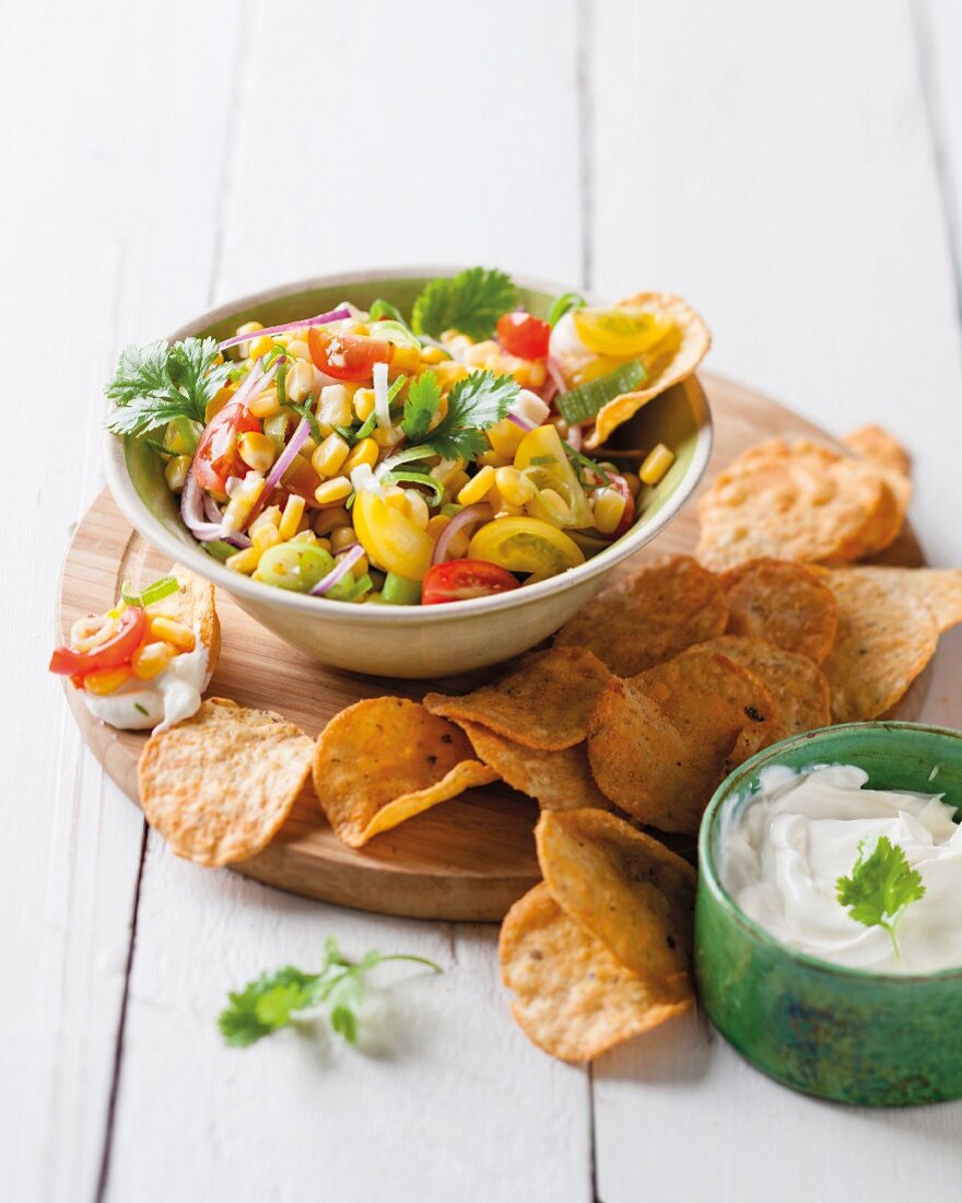 Ein Schälchen würzige Mais-Tomaten-Salsa mit Tortillachips