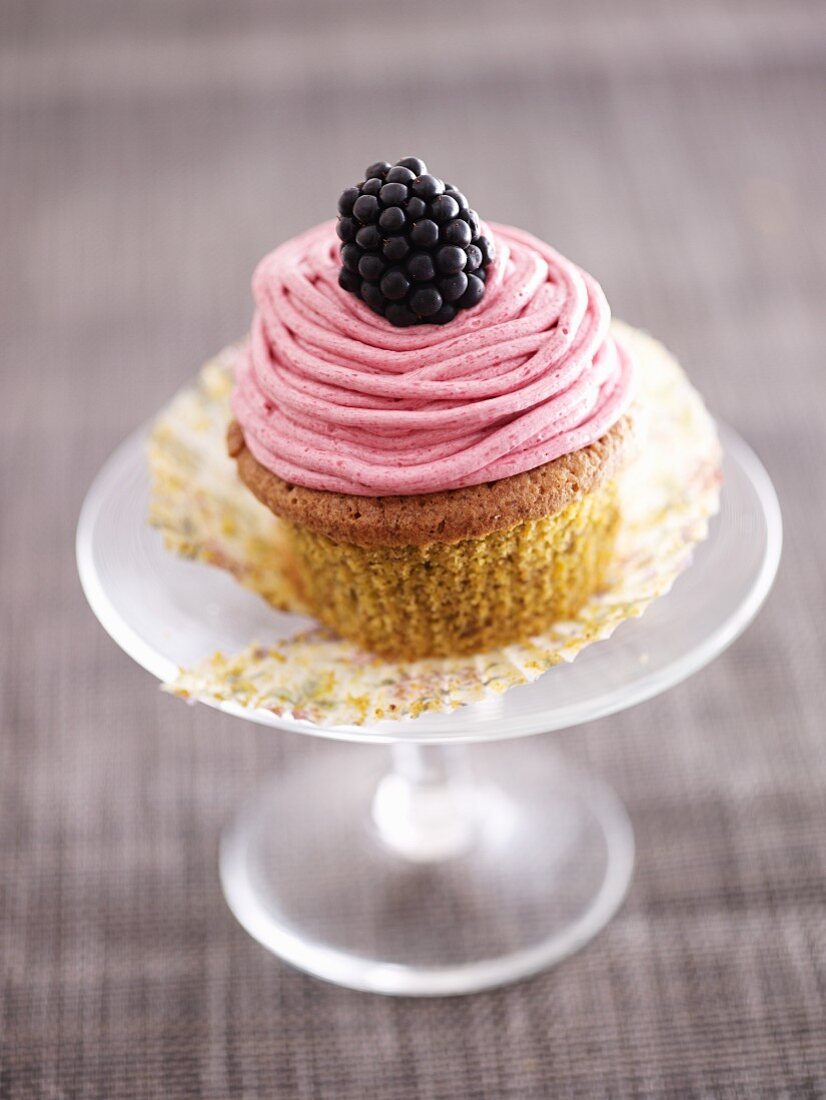 A pistachio and blackberry cupcake