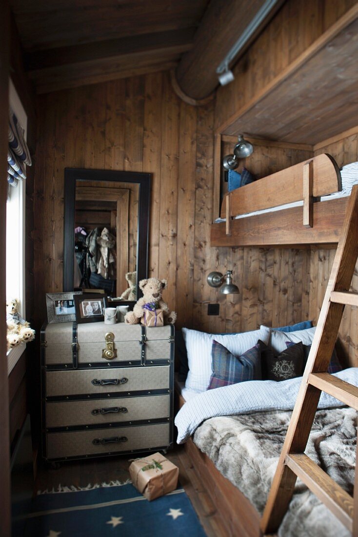 Schmales Kinderzimmer mit Stockbett in Holzhaus, seitlich Vintage Kommode