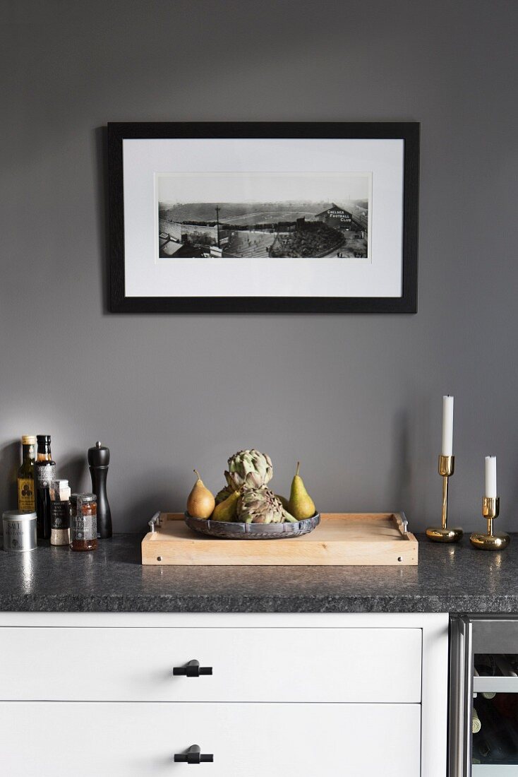 White kitchen counter with stone worksurface against grey-painted wall