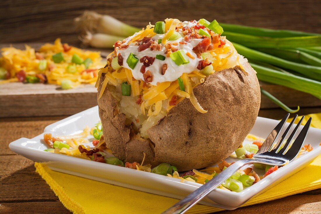 A twice baked potato with Cheddar cheese, onions, sour cream and bacon