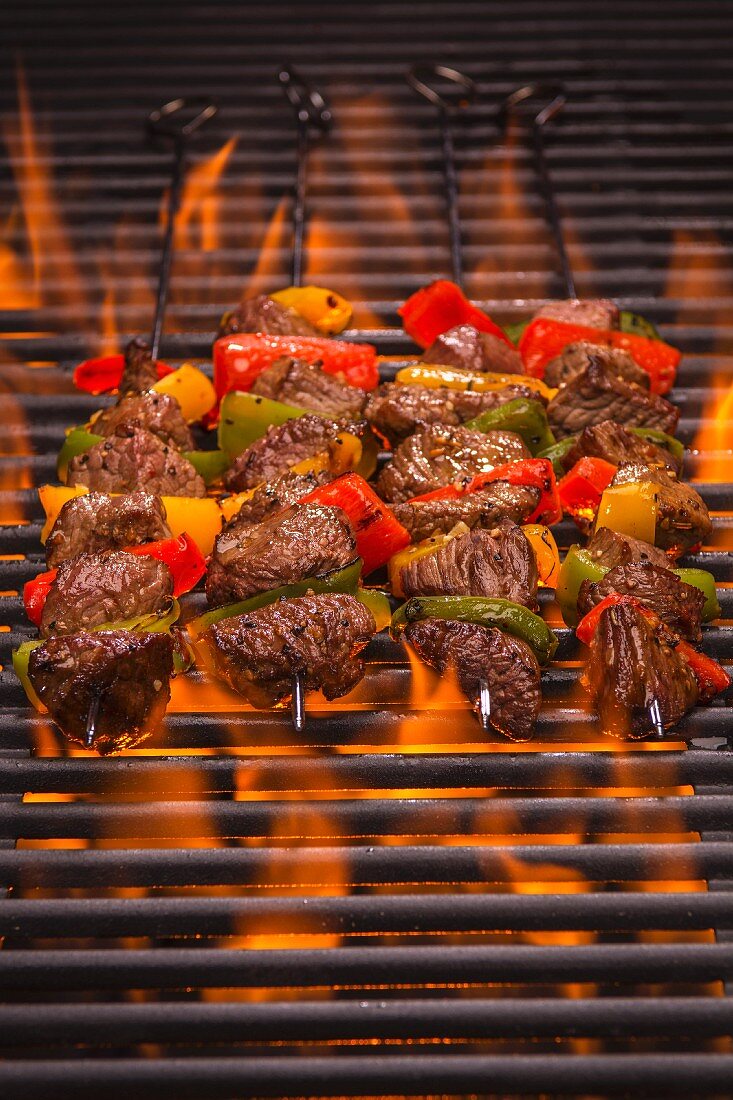 Beef skewers with peppers on a flaming grill