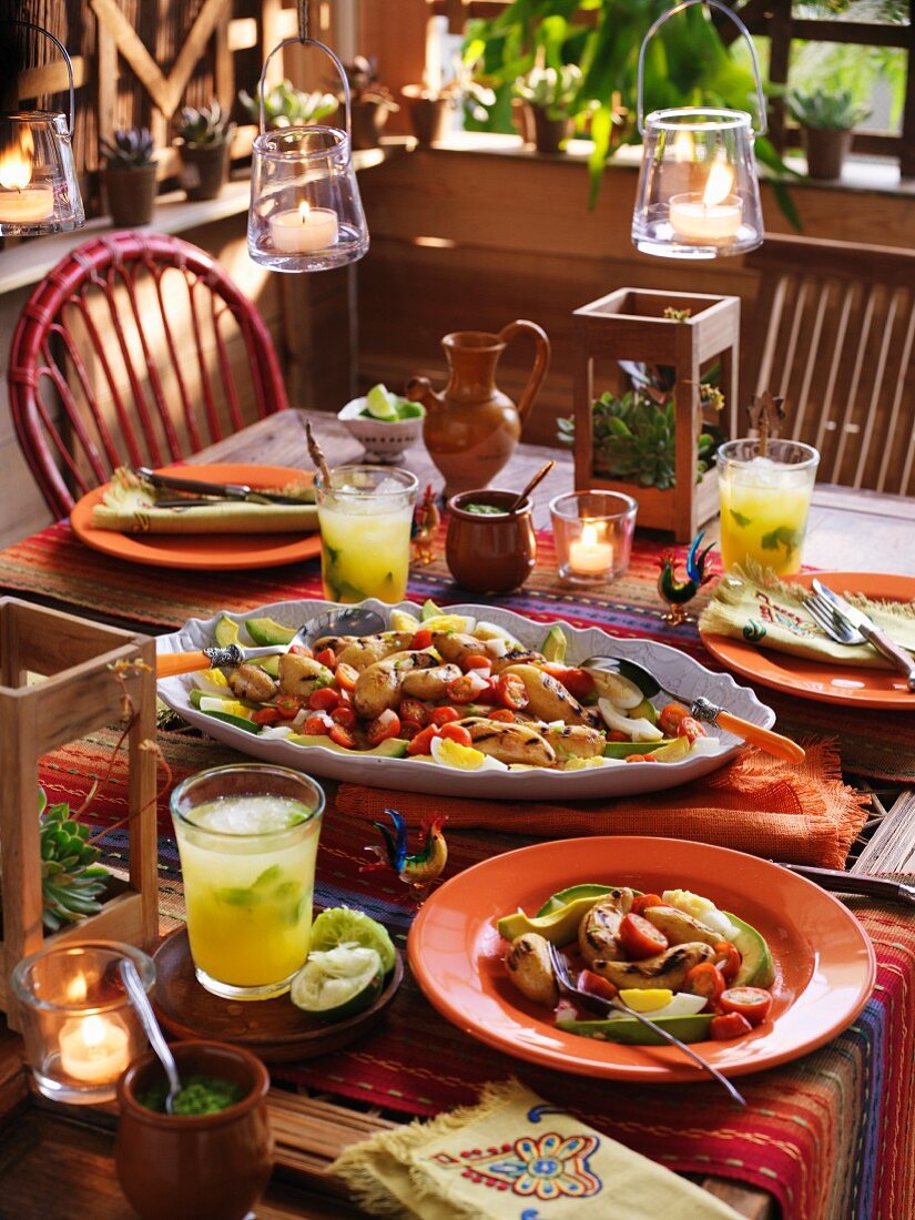 A table laid with a grilled potato, avocado and egg salad and drinks for a South American party