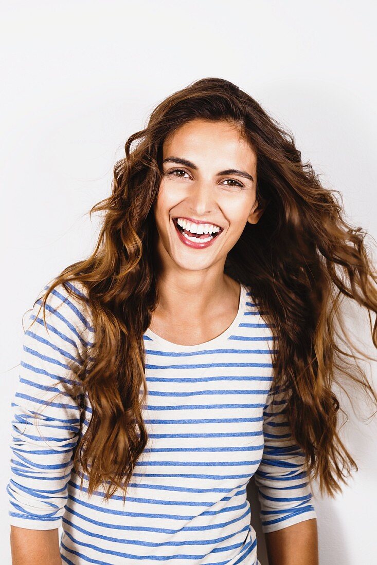 A young, brunette woman wearing a blue-and-white striped top