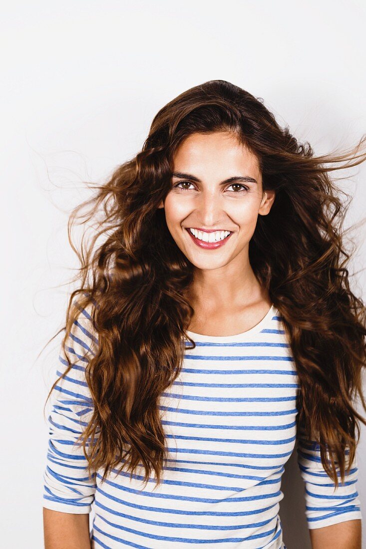 A young, brunette woman wearing a blue-and-white striped top