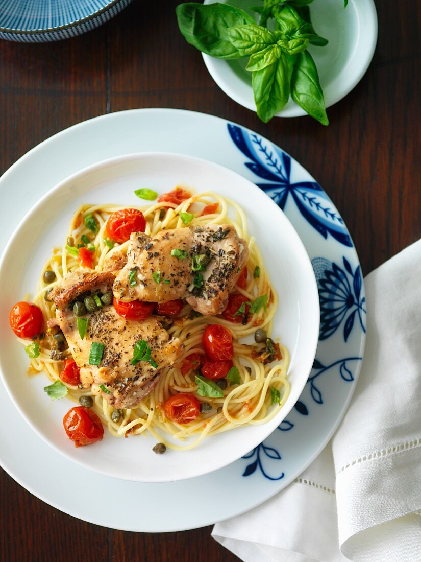 Herb chicken with cherry tomatoes and basil on spaghetti