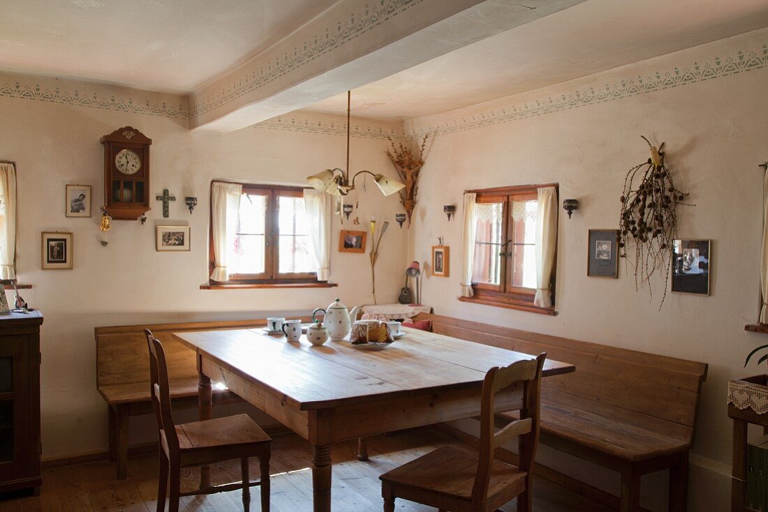 Restored farmhouse parlour with corner bench and rustic wooden table